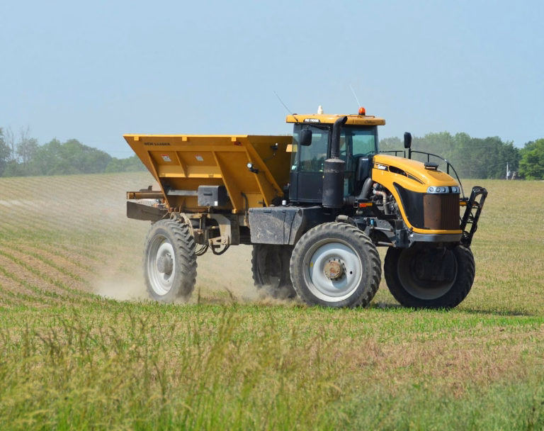 Spreader applying fertiliser in a paddock - phosphate fertiliser supply Australia